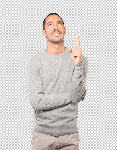 Happy young man pointing up with his finger