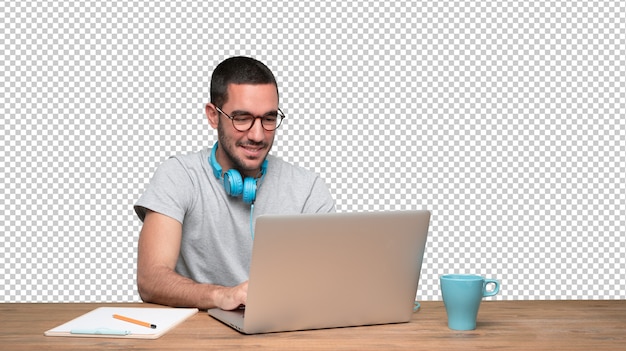 PSD happy young man sitting at his desk and using a headphones