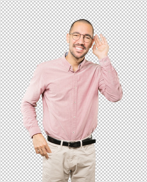 Happy young man smiling and making a gesture of trying to hear something