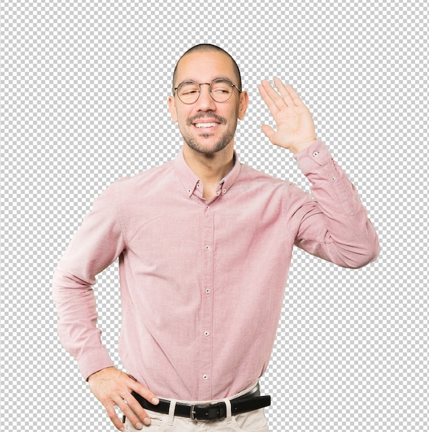 Happy young man smiling and making a gesture of trying to hear something