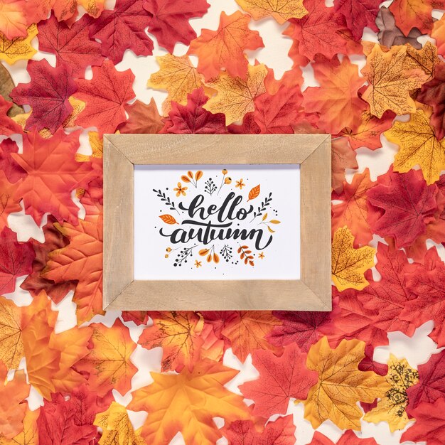 PSD hello autumn quote surrounded by dried colorful leaves