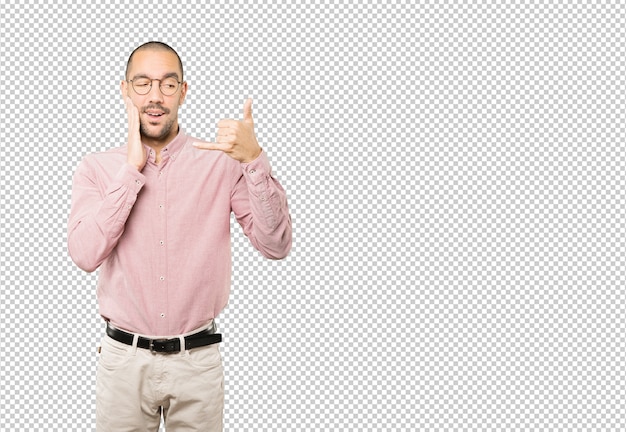 Hesitant young man making a gesture of calling with the hand