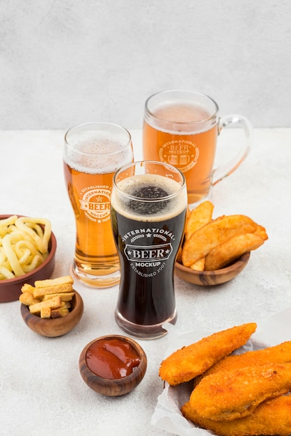 High angle of beer glasses with snacks