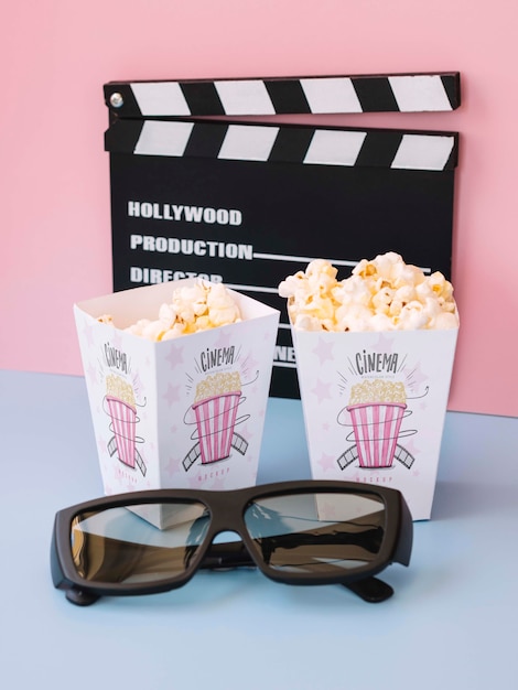 High angle of clapperboard with cinema popcorn and glasses