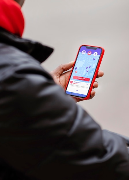 High angle of man holding smartphone with gps map mock-up