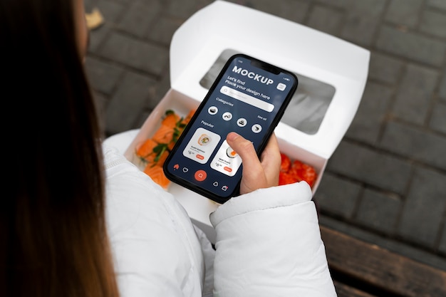 High angle woman with smartphone and sushi