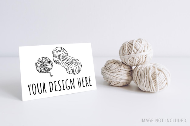 Horizontal postcard mockup with white yarn on a white table background Threads of cord boho image Space for text For macrame and bohemian handicrafts banners and advertisement Copyspace mockup