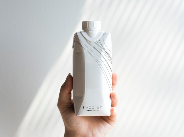 PSD human hand holding paper bottle mockup