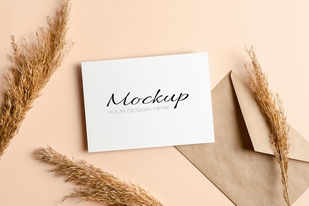 Invitation or greeting card mockup with envelope and dry plant decorations