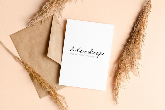 Invitation or greeting card mockup with envelope and dry plant decorations