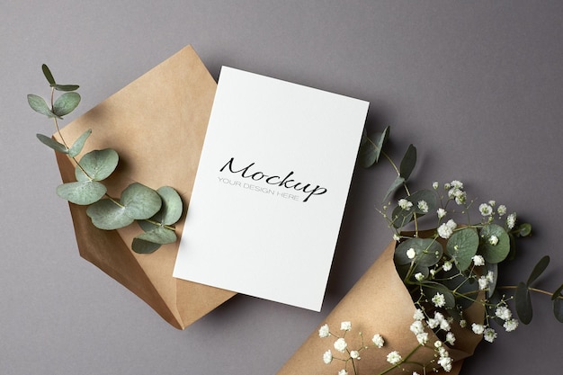 Invitation or greeting card mockup with envelope and eucalyptus and hypsophila flowers