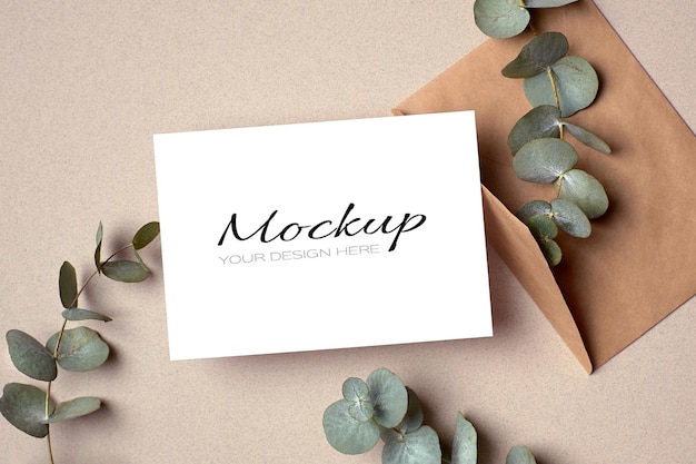 Invitation or greeting card mockup with envelope and green eucalyptus twigs