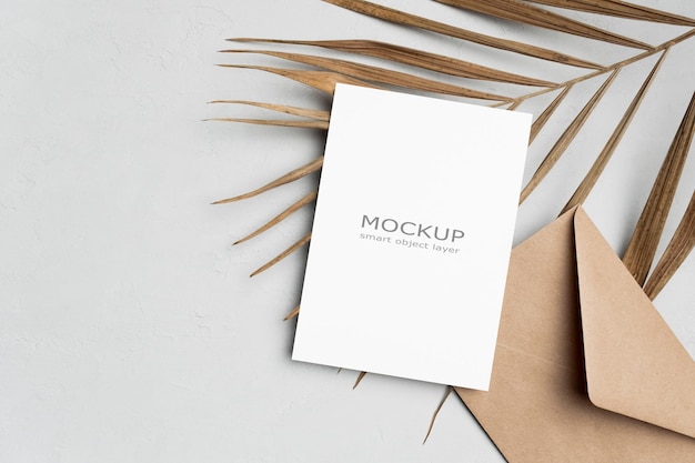 Invitation or greeting card mockup with envelope and palm tree leaf