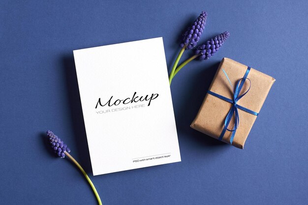 Invitation or greeting card mockup with gift box and spring blue muscari flowers