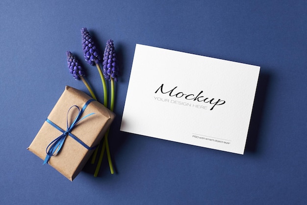 Invitation or greeting card mockup with gift box and spring blue muscari flowers