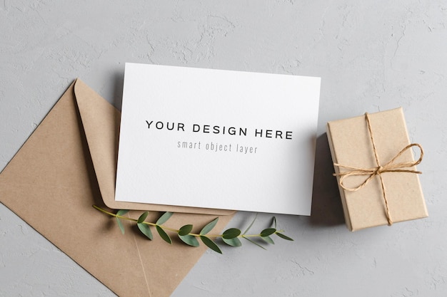 Invitation or greeting card mockup with gift envelope and eucalyptus twigs