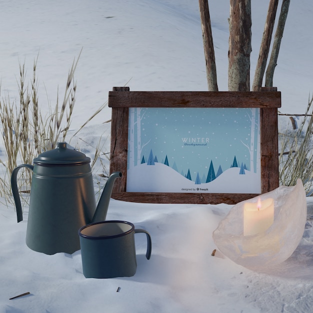 Kettle and cup beside frame with winter theme