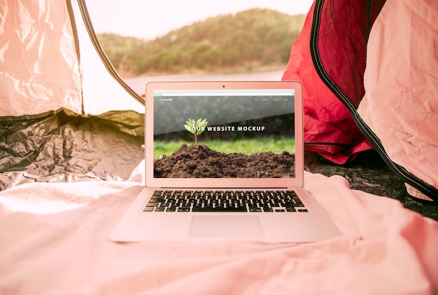 PSD laptop mockup with camping in nature concept