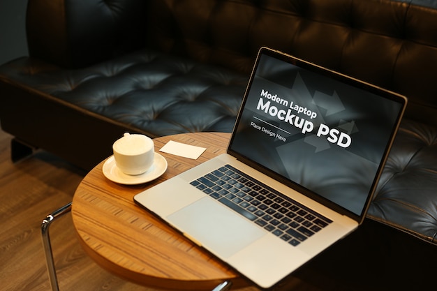 Laptop with coffee on round table mockup PSD