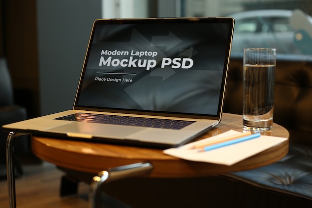 Laptop with coffee on round table mockup PSD