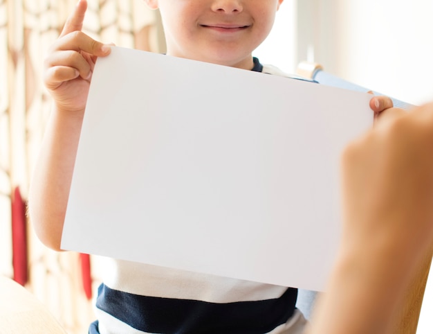 Little boy with a blank paper mockup