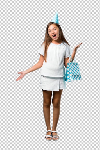 Little girl at a birthday party holding a gift bag with surprise and shocked facial expression