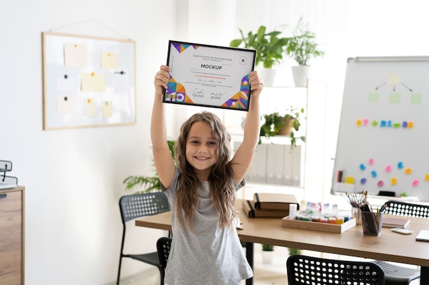 Little girl at home holding a certificate mock-up