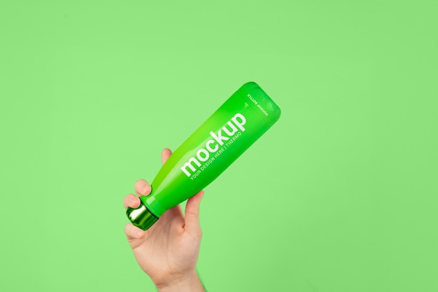 Male hand holding mock-up of green thermos bottle