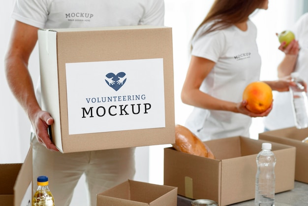 Male volunteer holding box of food donation