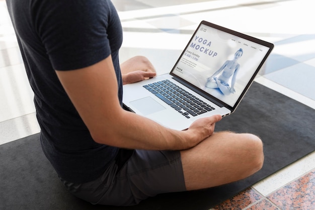 PSD man doing yoga with laptop mockup design