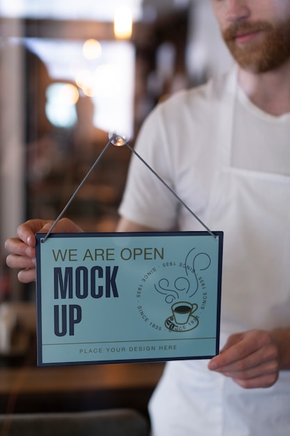 Man hanging we are open sign mock-up in business window