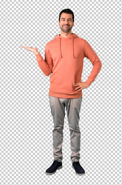 Man in a pink sweatshirt holding copy space imaginary on the palm to insert an ad