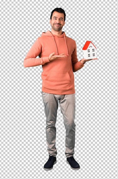 Man in a pink sweatshirt holding a little house