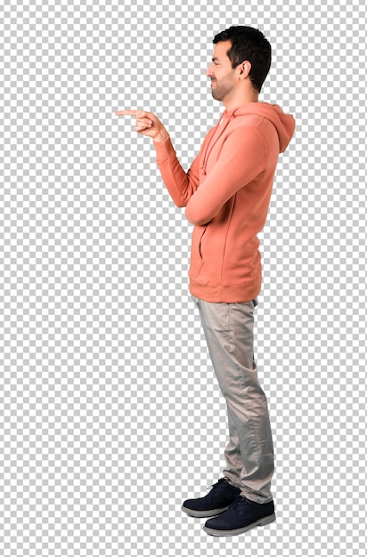 Man in a pink sweatshirt pointing finger to the side and presenting a product in lateral position