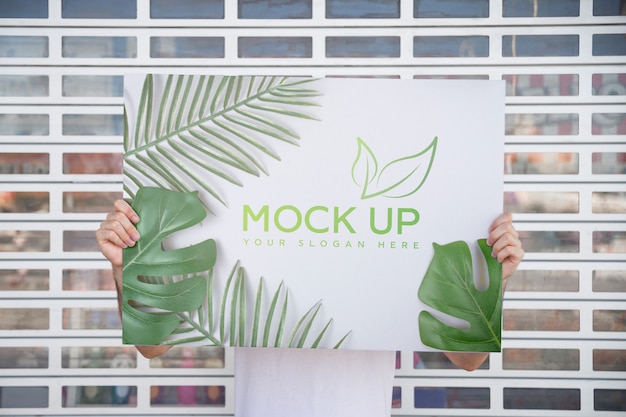 Man presenting poster mockup in front of gate