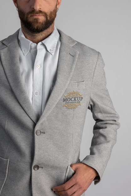 Man wearing stylish gray blazer with embroidery emblem