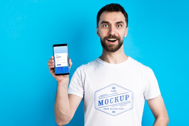 Man in white shirt showing mobile phone medium shot