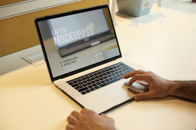 Man working with laptop at office workplace mockup psd