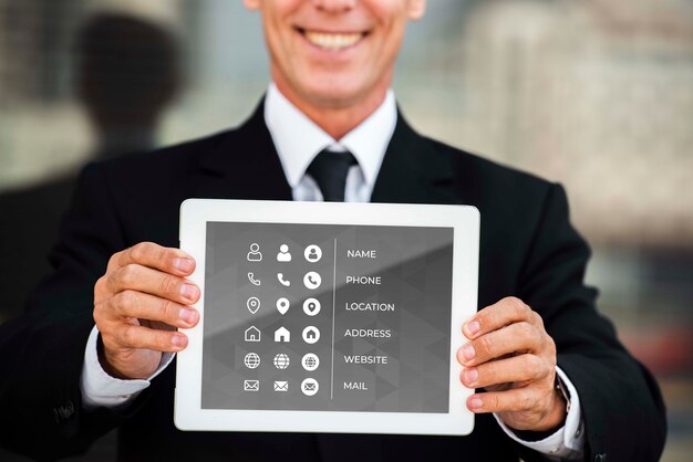 PSD medium shot of smiley man showing tablet for marketing purposes