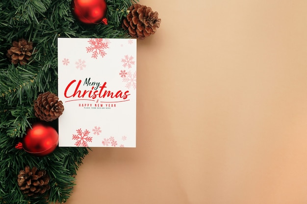 Merry Christmas greeting card mockup with pine leaves decorations