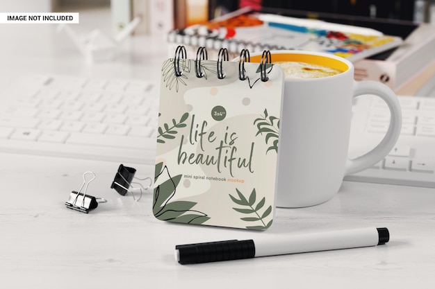 Mini spiral notebook near coffee cup mockup