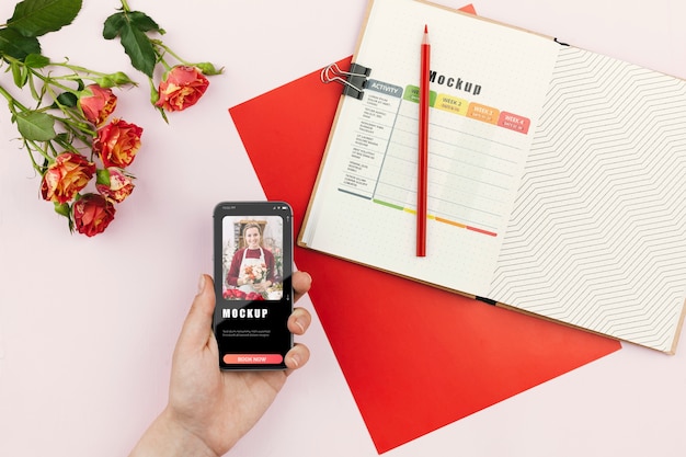 Mobile beside agenda and flowers on desk