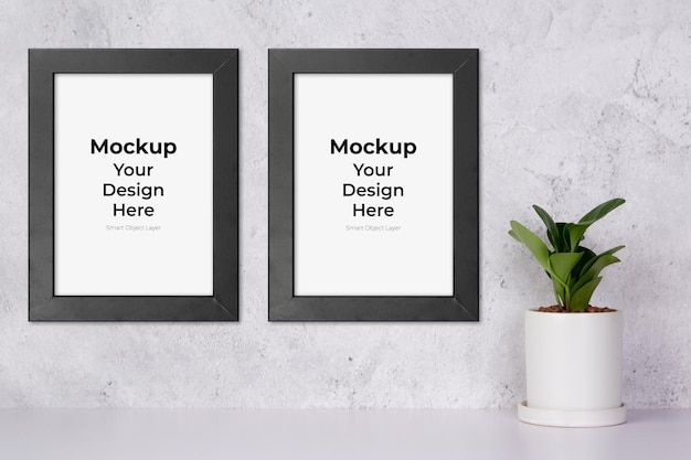 Mockup black frame vertical and plants in pot on table top at home, mock up poster for presentation on desk, your design for gallery photo and picture, border template and decoration for advertising.