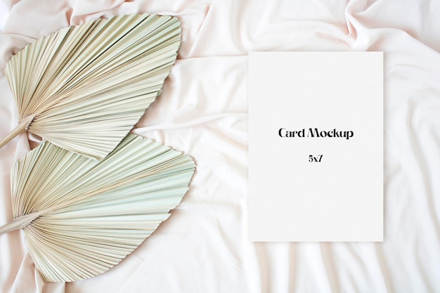 Mockup card with leaf palm on the nude fabric