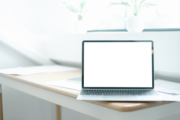 Mockup image of laptop on wood table with equipment of the mobile application graphic designer