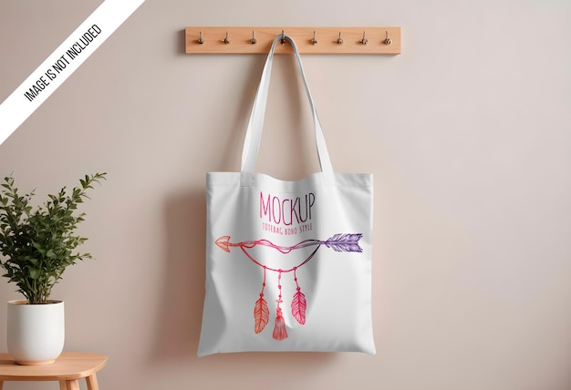 PSD mockup of a plain cotton canvas tote bag hanging on a wall hook