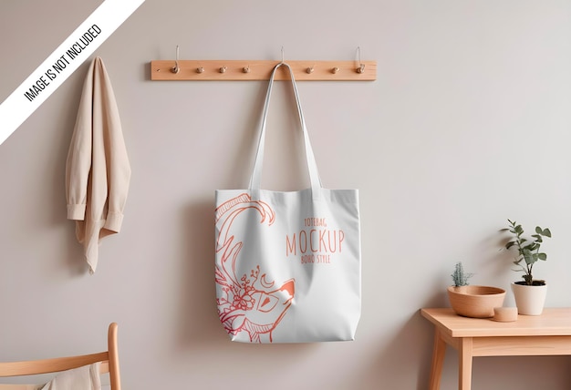 mockup of a plain cotton canvas tote bag hanging on a wall hook