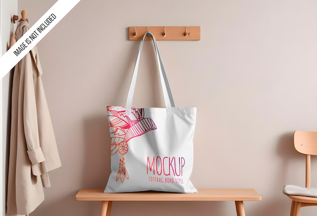 PSD mockup of a plain cotton canvas tote bag hanging on a wall hook