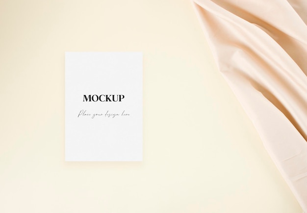 Mockup wedding invitation card with nude fabric on the beige background