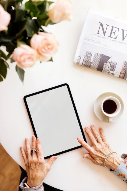 Old woman using a digital tablet in a cafe mockup